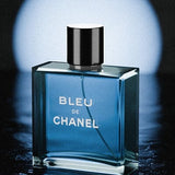 Bleu de Chanel perfume bottle on a reflective surface with a blue gradient background